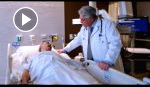 Doctor talking to a patient laying in bed.